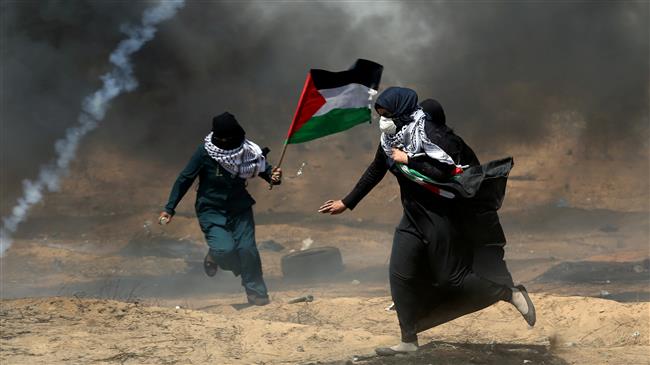 Two female demonstrators run for cover during a protest where Palestinians demand the right to return to their homeland, at the Gaza border in the southern Gaza Strip on May 25, 2018. (Photo by Reuters)
