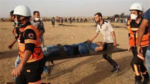 Palestinian paramedics carry away a protester injured during a demonstration along the Gaza Strip’s border, east of Khan Yunis, on May 25, 2018. (Photo by AFP)
