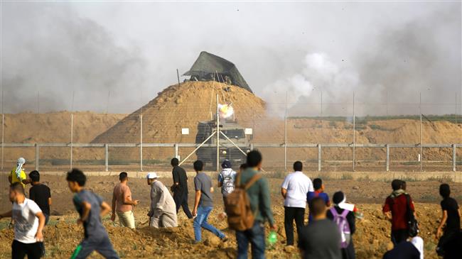 Palestinians confront Israeli forces as tear gas are shot during a demonstration along the border between the occupied territories and the Gaza strip, east of Gaza City, on May 25, 2018. (Photo by AFP)
