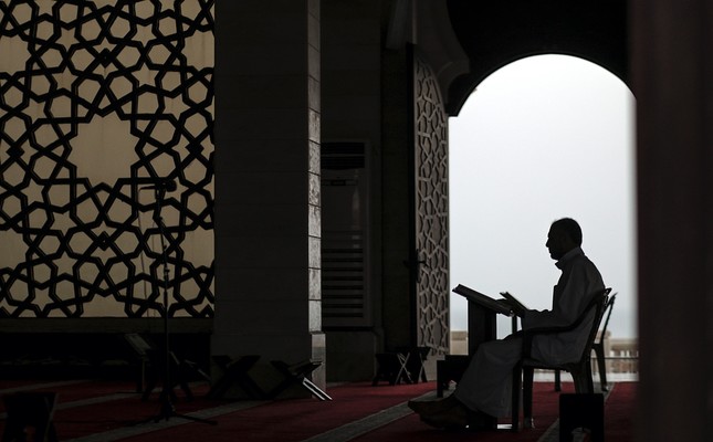 Man reads Quran in mosque before iftar.

