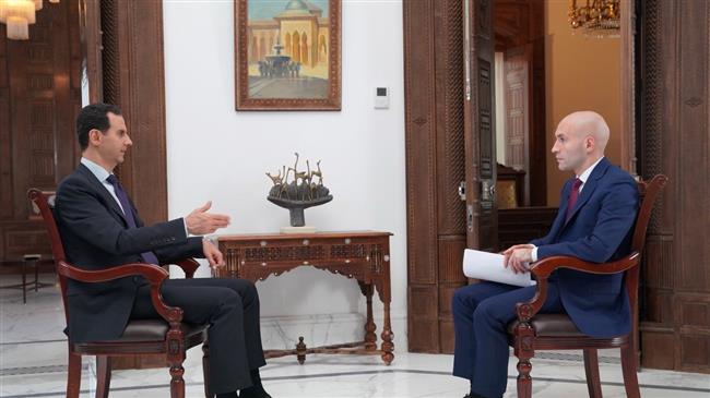 The photo shows Syria’s President Bashar al-Assad speaking during an interview with Russia