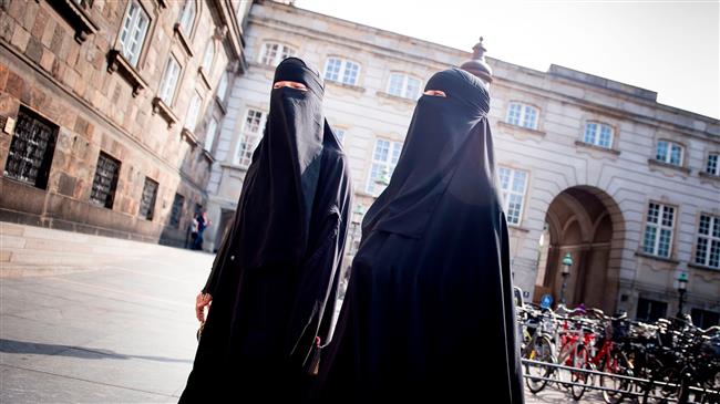 The photo shows two women wearing burqa outside the parliament in Denmark