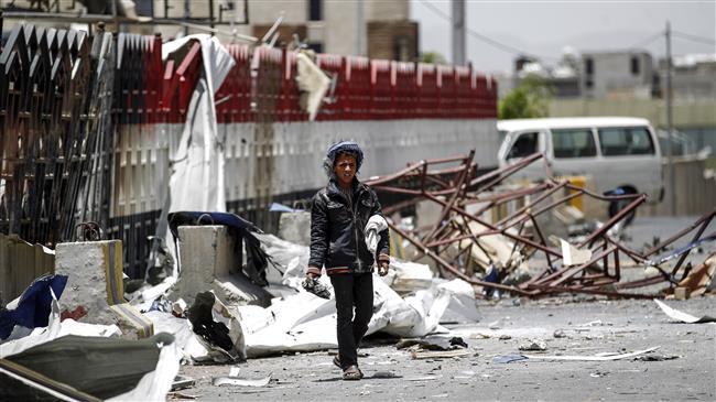 A Yemeni boy walks through the rubble and debris of a destroyed petrol station that was hit by a Saudi airstrike in the capital Sana