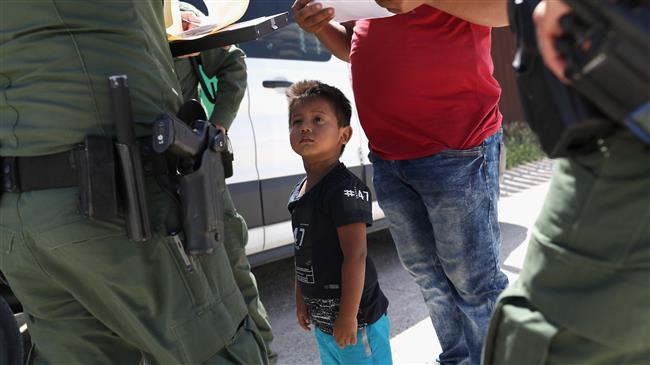 A boy and father from Honduras are taken into custody by US Border Patrol agents near the US-Mexico Border on June 12, 2018 near Mission, Texas. (Photo by AFP)
