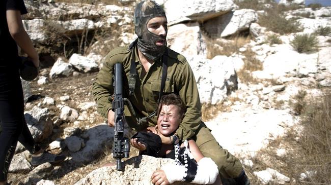 The file photo shows an Israeli soldier detaining a 12-year-old Palestinian boy in the West Bank.
