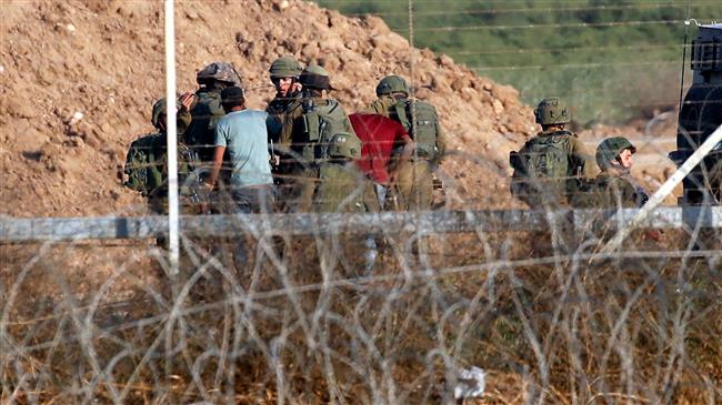 Israeli soldiers arrest Palestinians who allegedly tried to approach the Israeli fence during clashes east of Gaza City on May 15, 2018. (Photo by AFP)
