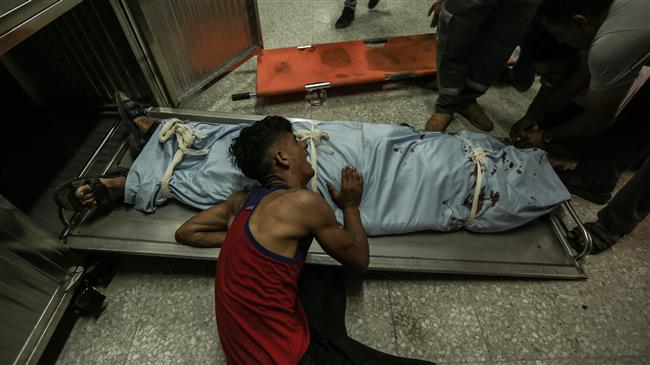 The brother of Palestinian Sabri Ahmad Abu Khadir, 24, mourns over his body at the morgue of al-Shifa Hospital in Gaza City, on June 18, 2018. (Photo by AFP)
