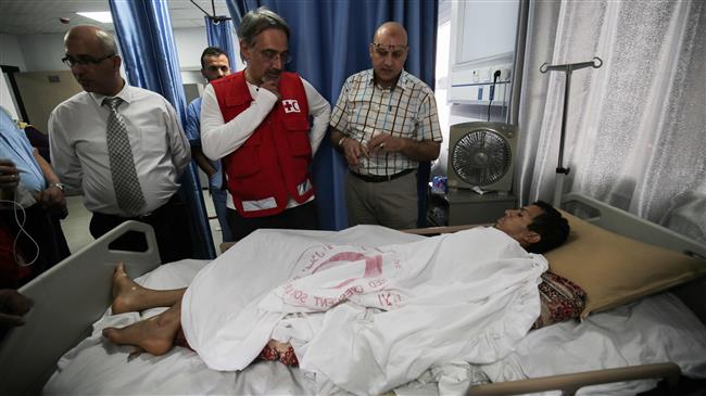 Francesco Rocca (2nd-L), the President of the International Federation of Red Cross and Red Crescent Societies, meets a Palestinian, receiving treatment for wounds sustained during protests at the Gaza border, during his tour of the Red Crescent Hospital in Khan Yunis in the southern Gaza Strip, on May 22, 2018. (Photo by AFP)
