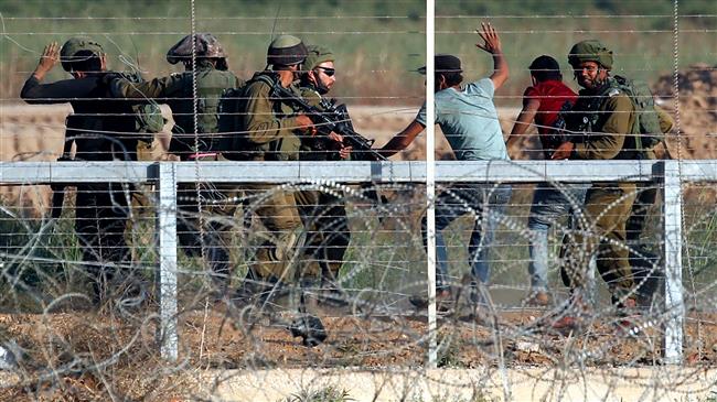 Israeli soldiers arrest the Palestinians who tried to approach the Gaza fence during clashes east of Gaza City on May 15, 2018. (Photo by AFP)
