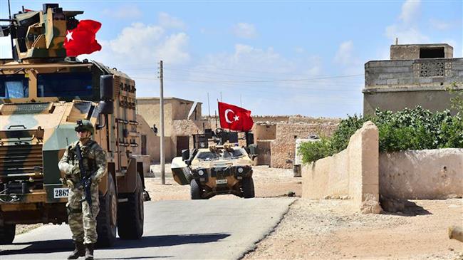 Turkish soldiers accompanied by armored vehicles patrol between the city of Manbij in northern Syria and an area Turkey controls, June 18, 2018. (Via AFP)