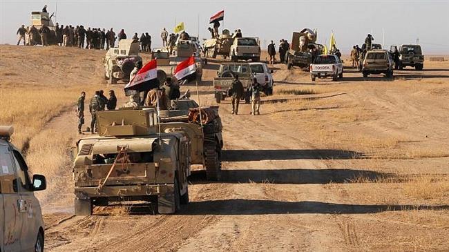Iraqi forces, supported by members of the Popular Mobilization Units (Hashd al-Sha’abi), advance in the western desert in the northern Iraqi region of al-Hadar, located 105 kilometers south of Mosul, on November 23, 2017, as they attempt to flush out remaining Daesh Takfiri militants. (Photo by AFP)
