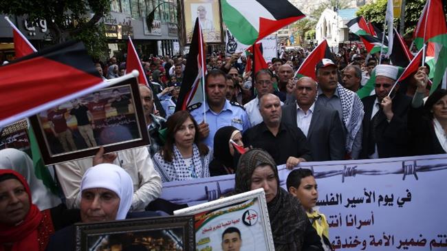 Palestinians hold portraits of relatives jailed in Israeli prisons as they protest to demand their release during a demonstration to mark the Prisoners