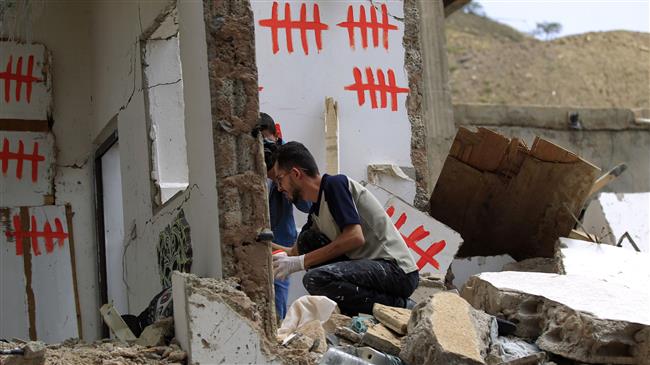 Yemeni artists paint graffiti on a damaged building that was hit by a previous air strike, during a campaign called 