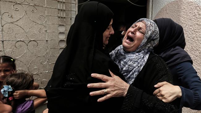 Palestinians and relatives mourn over the death of 15-year-old protester Uthman Rami Hals during his funeral in Gaza City on July 14, 2018. (Photo by AFP)
