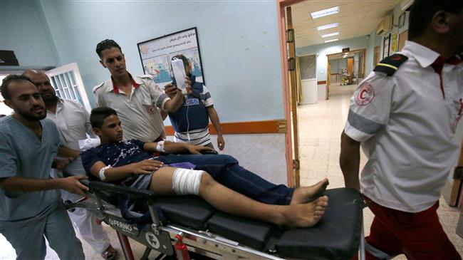 Palestinian paramedics push a youth, who was injured during Israeli bombardment, as he lies on a gurney into a hospital in Khan Yunis in the southern Gaza Strip on July 20, 2018. (Photo by AFP)
