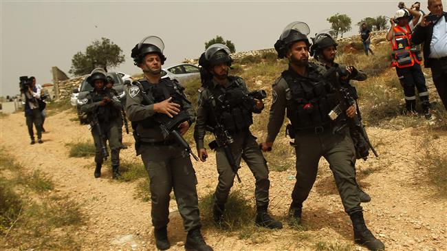 Israeli forces stand guard near the separation fence between the city of Bethlehem and Jerusalem al-Quds in the occupied West Bank on May 10, 2018. (Photo by AFP)
