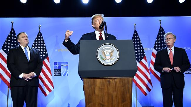 US President Donald Trump (C) is accompanied by US Secretary of State Mike Pompeo (L) and US National Security Adviser John Bolton as he addresses a press conference on the second day of the North Atlantic Treaty Organization (NATO) summit in Brussels on July 12, 2018. (Photo by AFP)
