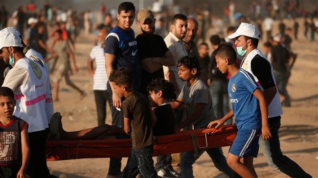 Palestinians are carrying a boy injured during a demonstration against the occupation of Palestinian land by Israel, eastern Gaza City, July 27, 2018. (AFP)
