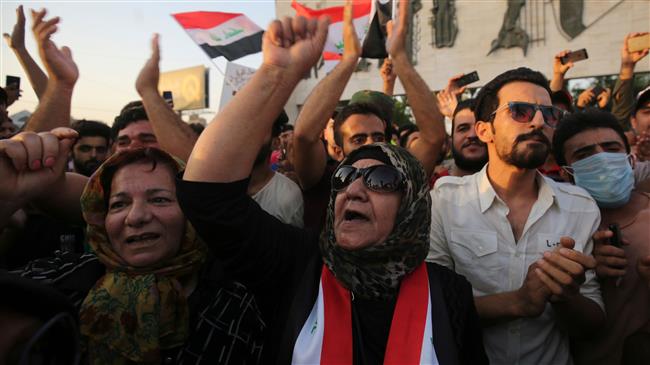 Iraqis wave national flags and hold up signs during a demonstration in the capital Baghdad