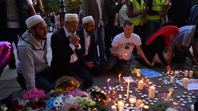In this file photo taken on May 23, 2017 people pray and light candles set up in front of floral tributes in Albert Square in Manchester, northwest England on May 23, 2017, in solidarity with those killed and injured in the May 22 terror attack at the Ariana Grande concert at the Manchester Arena. (AFP photo)
