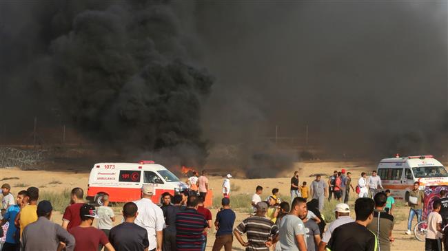 Palestinian protesters gather as black smoke rises from burning tires during a demonstration near the Gaza fence, in Khan Yunis in the southern Gaza Strip on August 3, 2018. (Photo by AFP)
