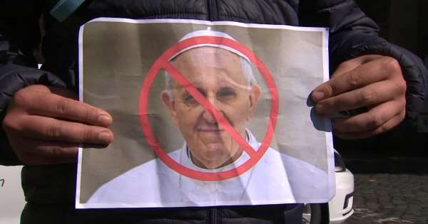 Protesters holding baby shoes and rainbow flags greet Pope Francis in Ireland
