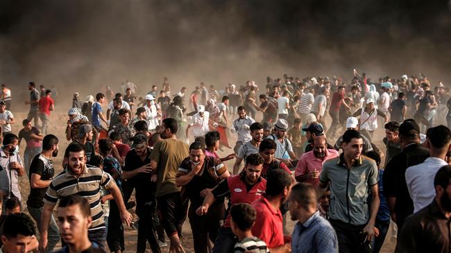 Palestinian protesters demonstrate near the fence east of Gaza City on August 31, 2018, as smoke rises from burning tires and Israeli tear gas canisters. (Photo by AFP)
