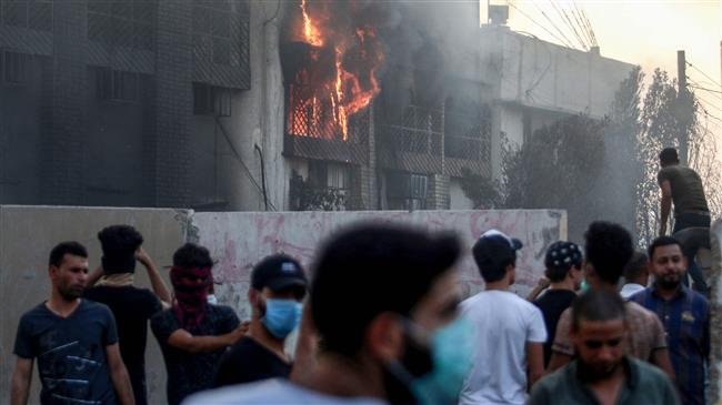 Iraqi protesters gather outside the burnt-down local government headquarters in the southern city of Basra on September 7, 2018 during demonstrations against poor public services. (Photo by AFP)
