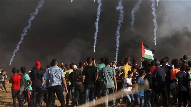 Palestinian protesters watch as teargas grenades fired by Israeli forces fall during clashes following a demonstration along the border between the Gaza Strip and the Israeli-occupied territories east of Gaza City on September 7, 2018. (Photo by AFP)
