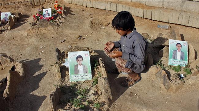 A Yemeni child recites a prayer by the graves of schoolboys who were killed while on a bus that was hit by a Saudi-led coalition airstrike in August. (Photo by AFP)
