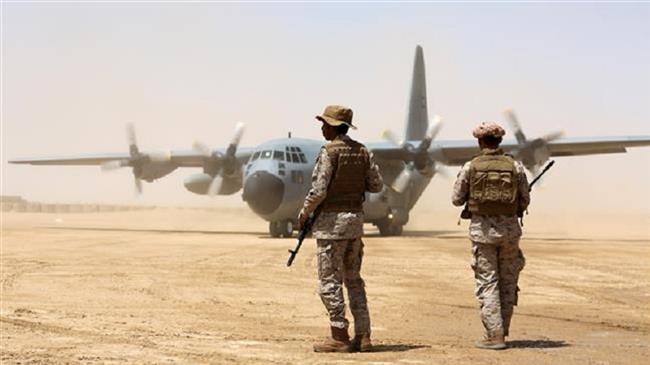 Saudi soldiers stand guard before aid supplies are unloaded from a cargo plane at an airfield in Yemen