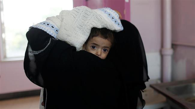 A woman carries a child at the malnutrition ward of al-Sabeen hospital in Sana