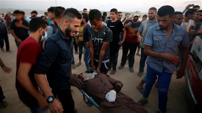 A Palestinian woman is evacuated after inhaling tear gas during a protest calling for lifting the Israeli blockade on Gaza on September 17, 2018. (Photo by Reuters)
