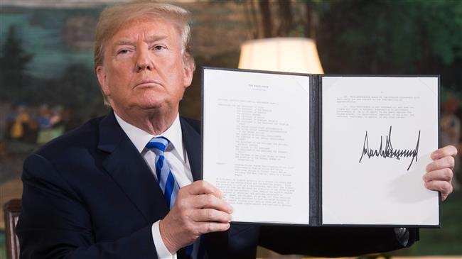 US President Donald Trump holds up a document reinstating sanctions against Iran after announcing the US withdrawal from the Iran nuclear deal, in the Diplomatic Reception Room at the White House, in Washington, DC, on May 8, 2018. (Photo by AFP)