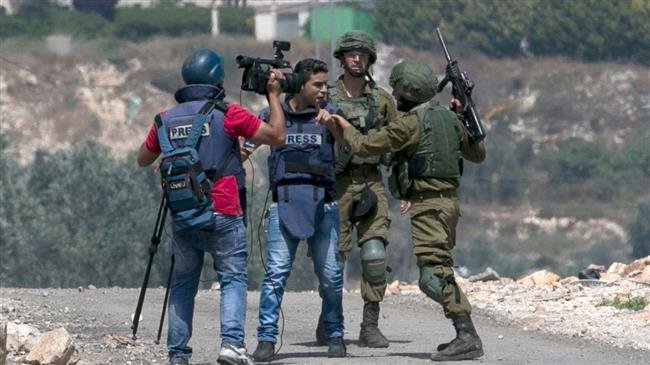 An Israeli soldier scuffles with a Palestinian journalist as Palestinian protesters clash with Israeli forces during a weekly demonstration against the expropriation of Palestinian land by Israel in the village of Kfar Qaddum, near Nablus in the occupied West Bank, on May 11, 2018. (Photo by Getty Images)
