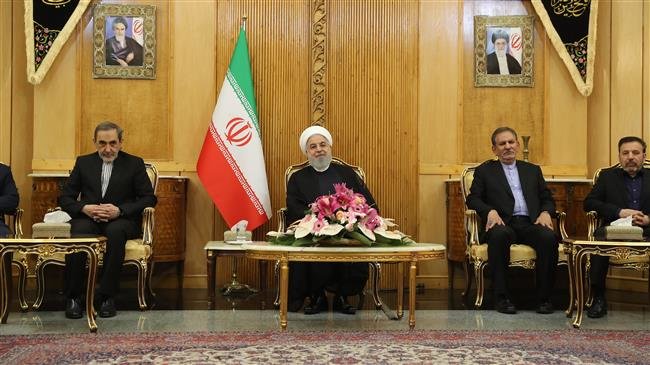 Iranian President Hassan Rouhani (C) talks to reporters upon arrival at Tehran