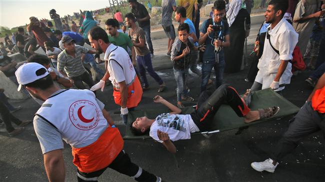 Palestinian paramedics carry an injured man as protesters demonstrate in the northern Gaza Strip on October 3, 2018. (Photo by AFP)
