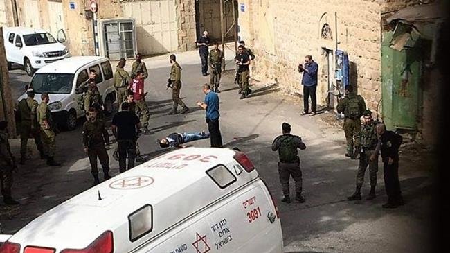 Israeli forces are seen around the body of the Palestinian man whom they shot dead in al-Khalil (Hebron) on October 22, 2018.
