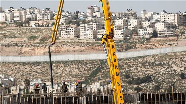 This file picture shows the occupied West Bank town of al-Ram overlooking the construction site for the Israeli settlement of Neve Ya’akov, with the separation wall in between. (Photo by European Pressphoto Agency)
