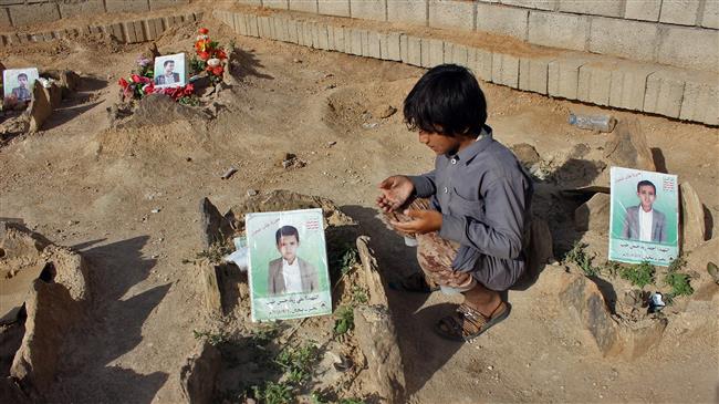 A Yemeni child recites a prayer by the graves of schoolboys who were killed while on a bus that was hit by a Saudi-led coalition airstrike on the Dahyan market in August, at a cemetery in the province of Sa’ada on September 4, 2018. (By AFP)
