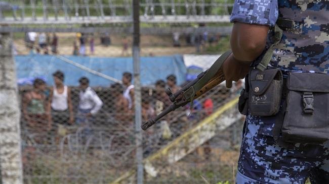 The file photo shows a Myanmar border guard police patrolling the fence in the "no man