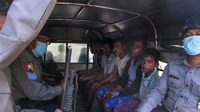 Police escort a group of Rohingya men and a boy in Kyauktan township south of Yangon on November 16, 2018 after their boat washed ashore. (Photo by AFP)
