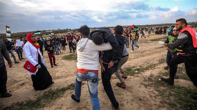 Palestinian youths carry away a protester who was injured during clashes following a demonstration along the border between the Gaza Strip and the Israeli-occupied territories, east of Gaza City on December 7, 2018. (Photo by AFP)
