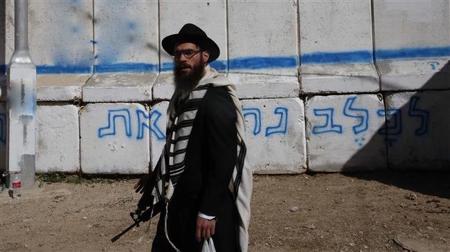 The file photo shows an Israeli settler standing guard in the occupied West Bank town of al-Khalil (Hebron) on November 3, 2018. (Photo by AFP)
