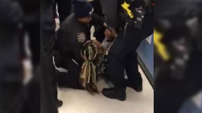 Screenshot of a Facebook video posted by Nyashia Ferguson showing a police officer violently ripping a baby from his mother at an incident at a Brooklyn food stamp office in New York City, United States.
